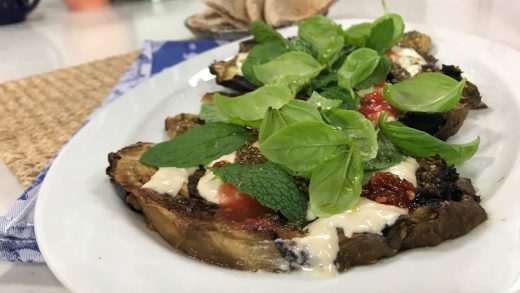 Charred whole eggplant with crushed tomatoes, basil and mint