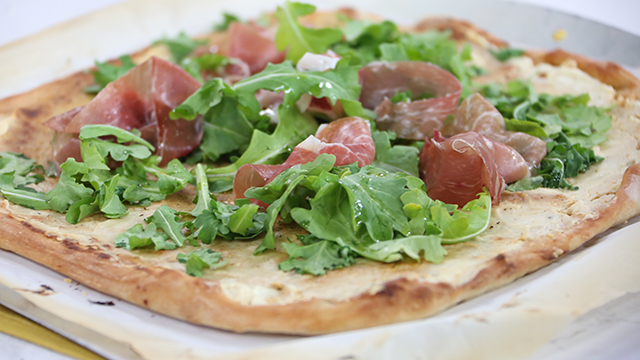 Goat cheese and honey pizza with prosciutto and arugula