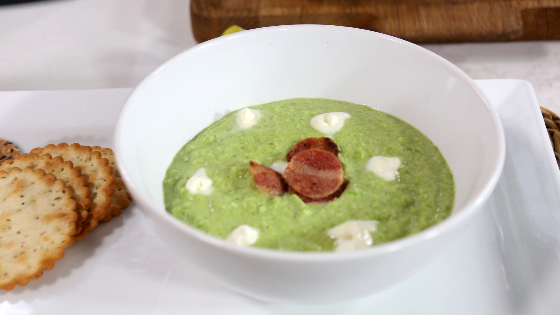 Pea soup with crème fraiche and crispy bacon chips