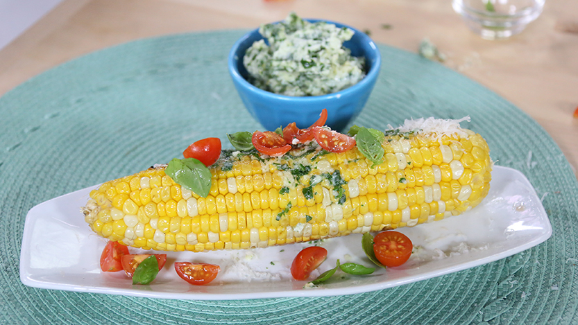 Grilled corn with garlic herb butter with tomatoes and parmesan