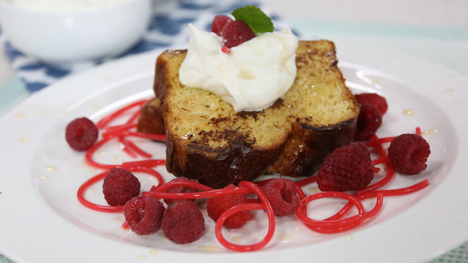 French toast with vanilla whipped cream, vanilla glaze and strawberry noodles