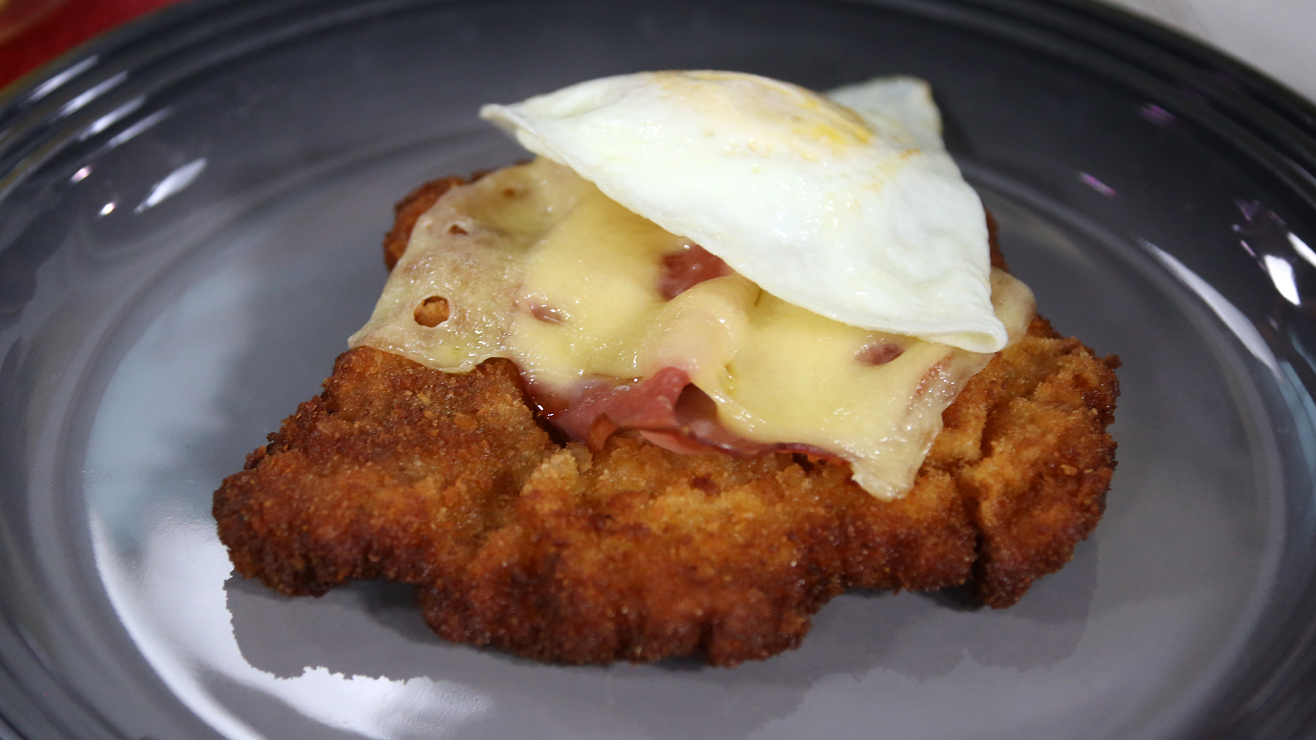 Cheese and egg topped pork schnitzel