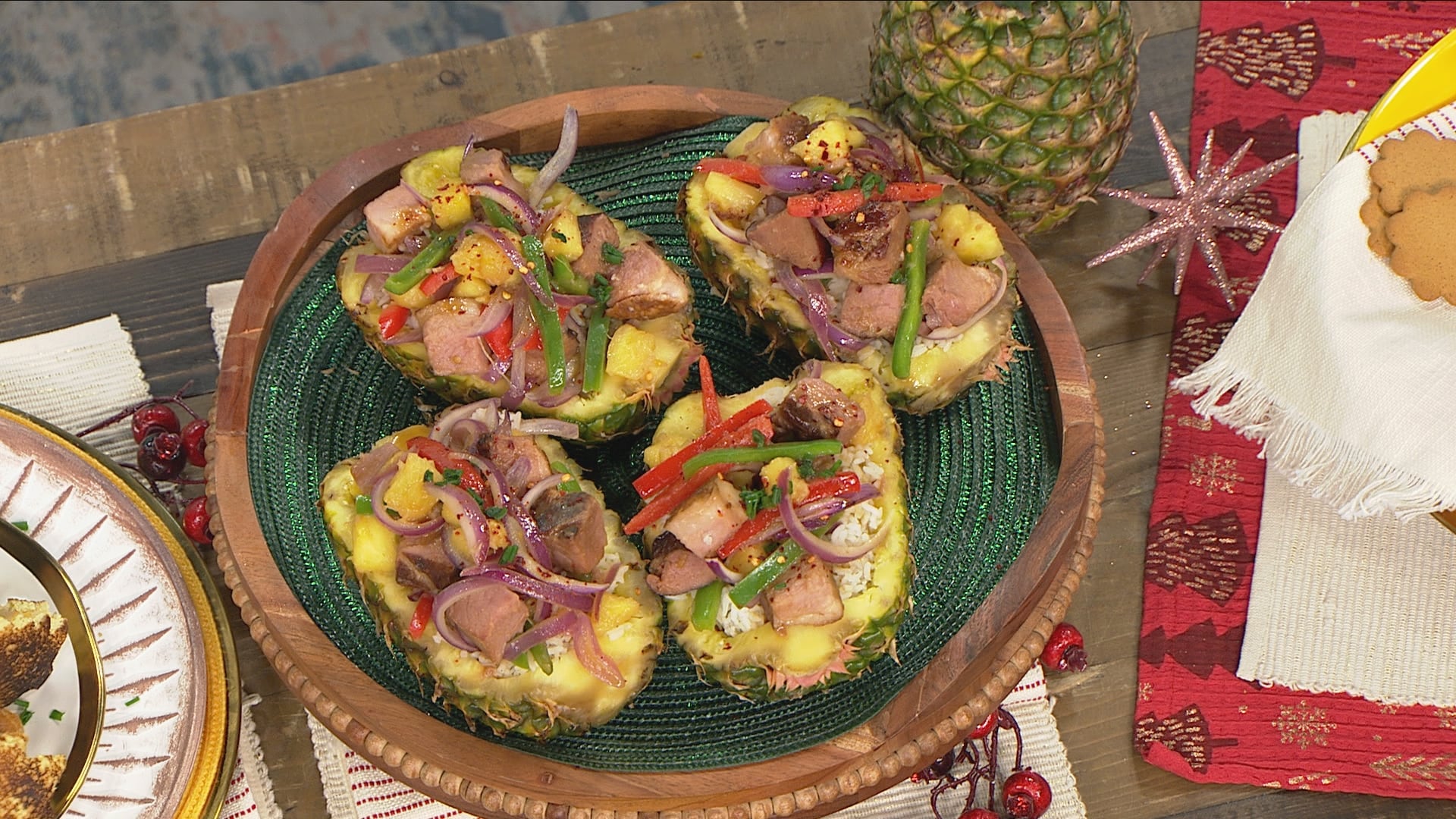 pineapple that has had the fruit removed (just the outer shell) filled with white jasmine rice, chunks of pink ham, green and red peppers, and red onions