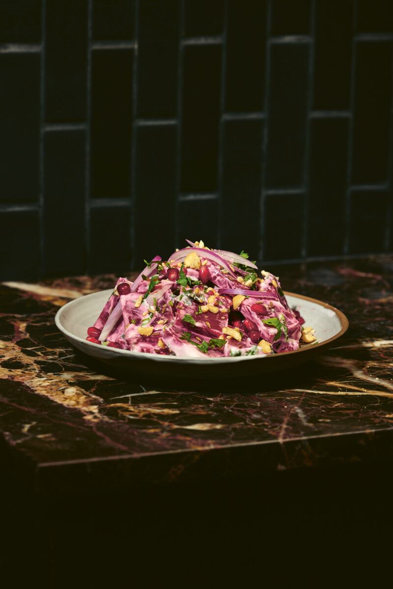 Chopped beets in a salad with white yogurt dressing and garnish of corn, parsley, and red onions